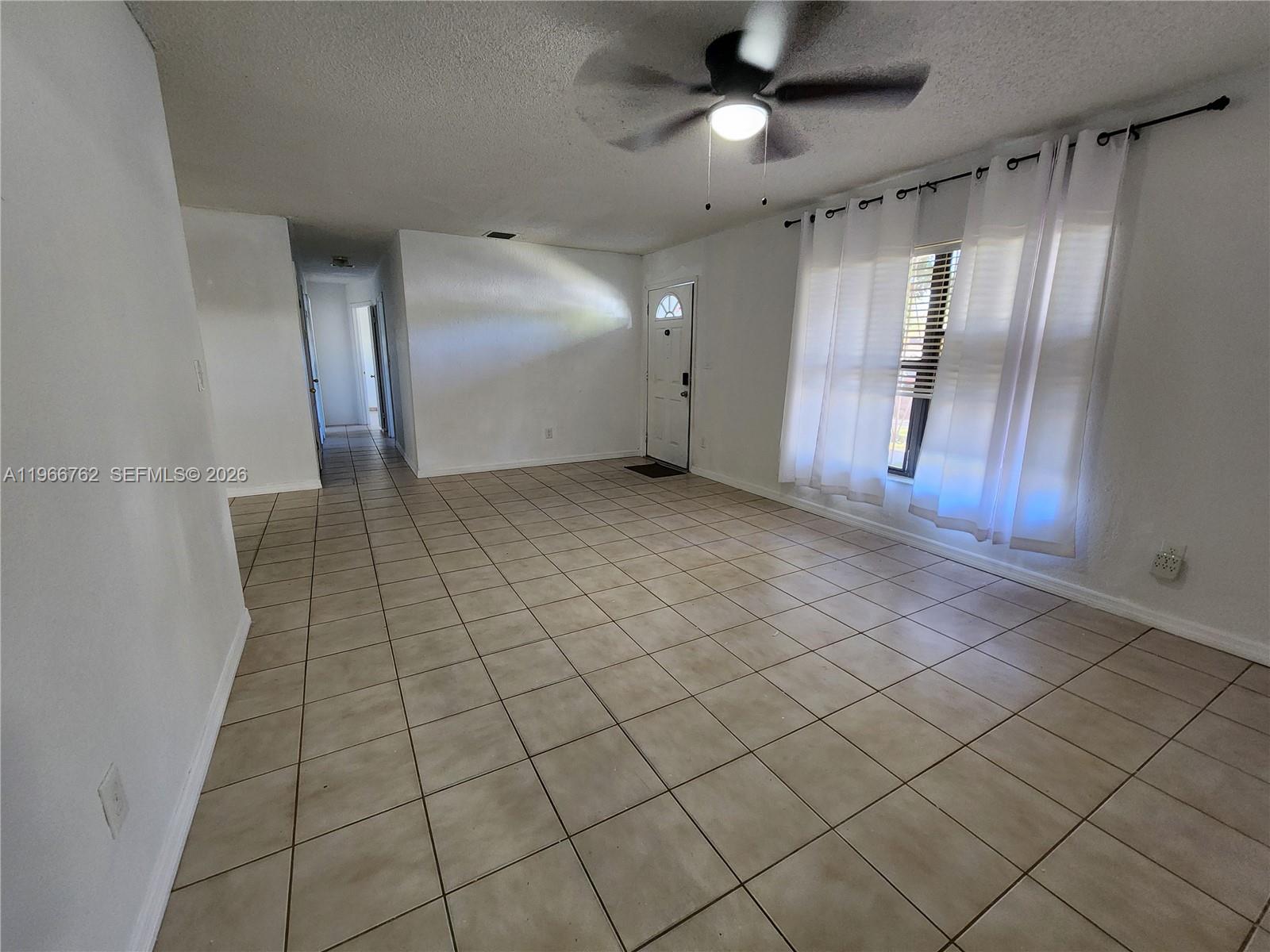 16311 Southwest 102nd Place, Unit A Miami, FL 33157 - Photo 8 of 15 an empty room with wooden floor and staircase