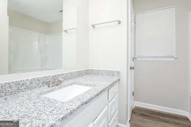 a bathroom with a granite countertop sink and a mirror