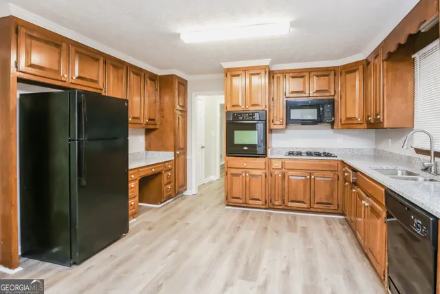 a kitchen with stainless steel appliances granite countertop a refrigerator a stove top oven a sink and dishwasher