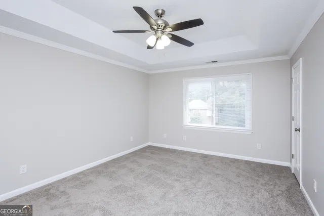 an empty room with a window and a ceiling fan
