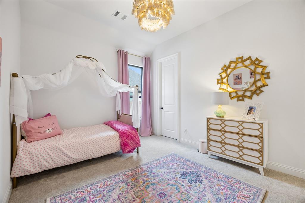 1717 Tolleson Drive Fort Worth, TX 76008 - Photo 26 of 40 a bedroom with a bed and a chandelier