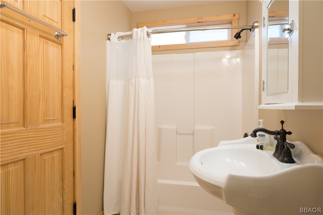 630 Summit Boulevard Big Bear Lake, CA 92315 - Photo 14 of 33 a bathroom with a sink a mirror and shower