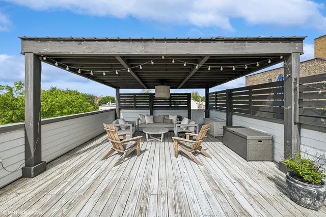 a view of a patio with table and chairs with wooden floor and fence