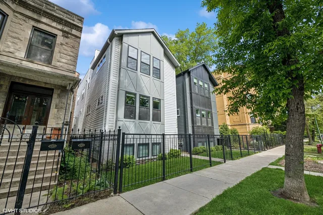 a view of a house with a small yard and wooden fence