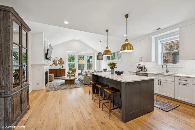 a kitchen with a sink a counter space appliances and a living room view