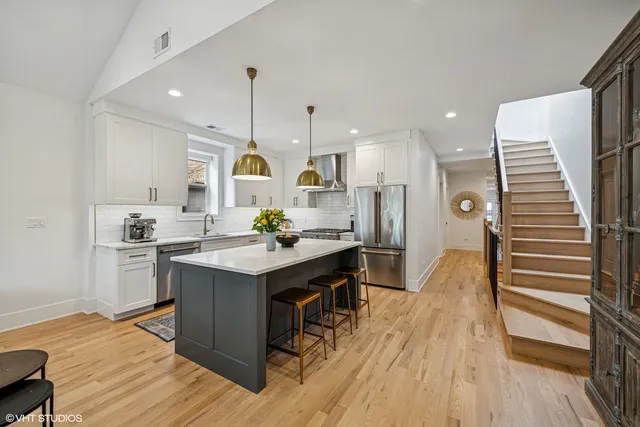 a kitchen with stainless steel appliances granite countertop a sink stove and wooden floor