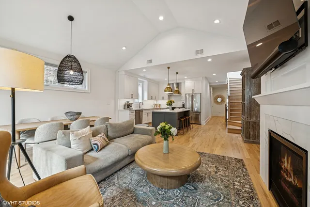 a living room with furniture a fireplace and a chandelier