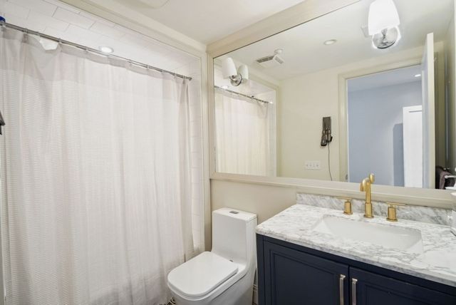 a bathroom with a granite countertop sink toilet and shower