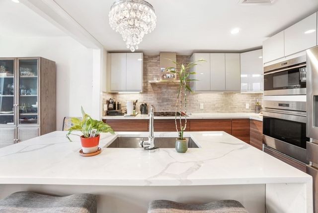 a kitchen with a stove a sink and cabinets