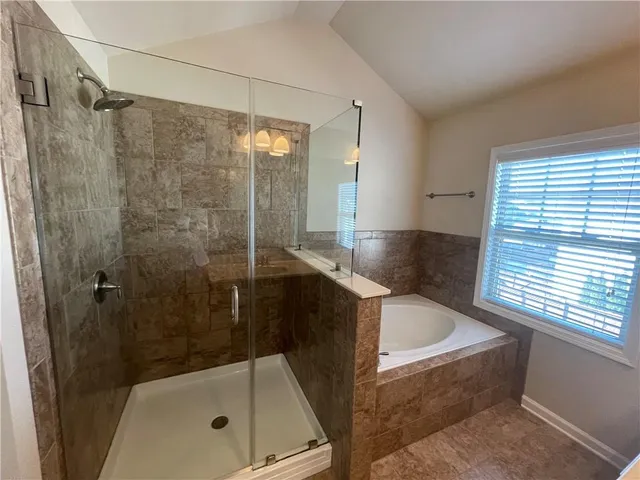 a bathroom with a tub a sink and glass door shower