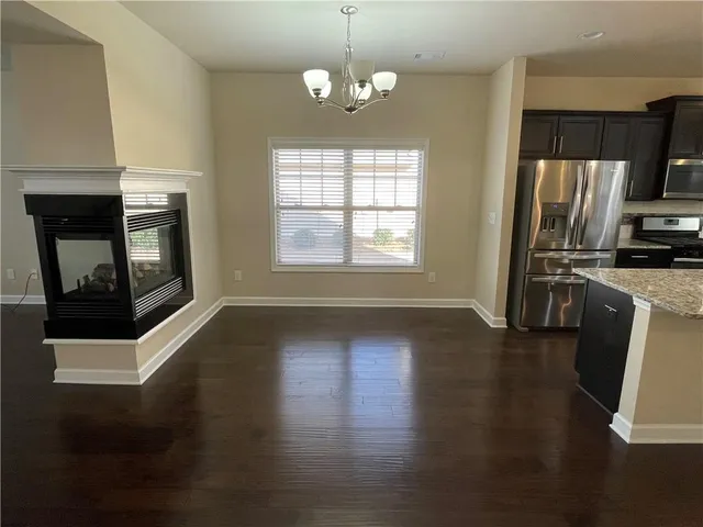 a view of a kitchen with a stove wooden floor windows and a fireplace