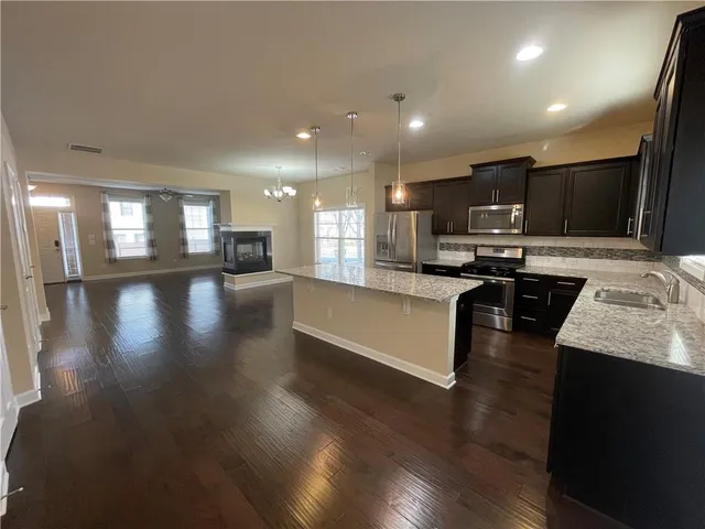 a large kitchen with stainless steel appliances lots of counter space and a sink