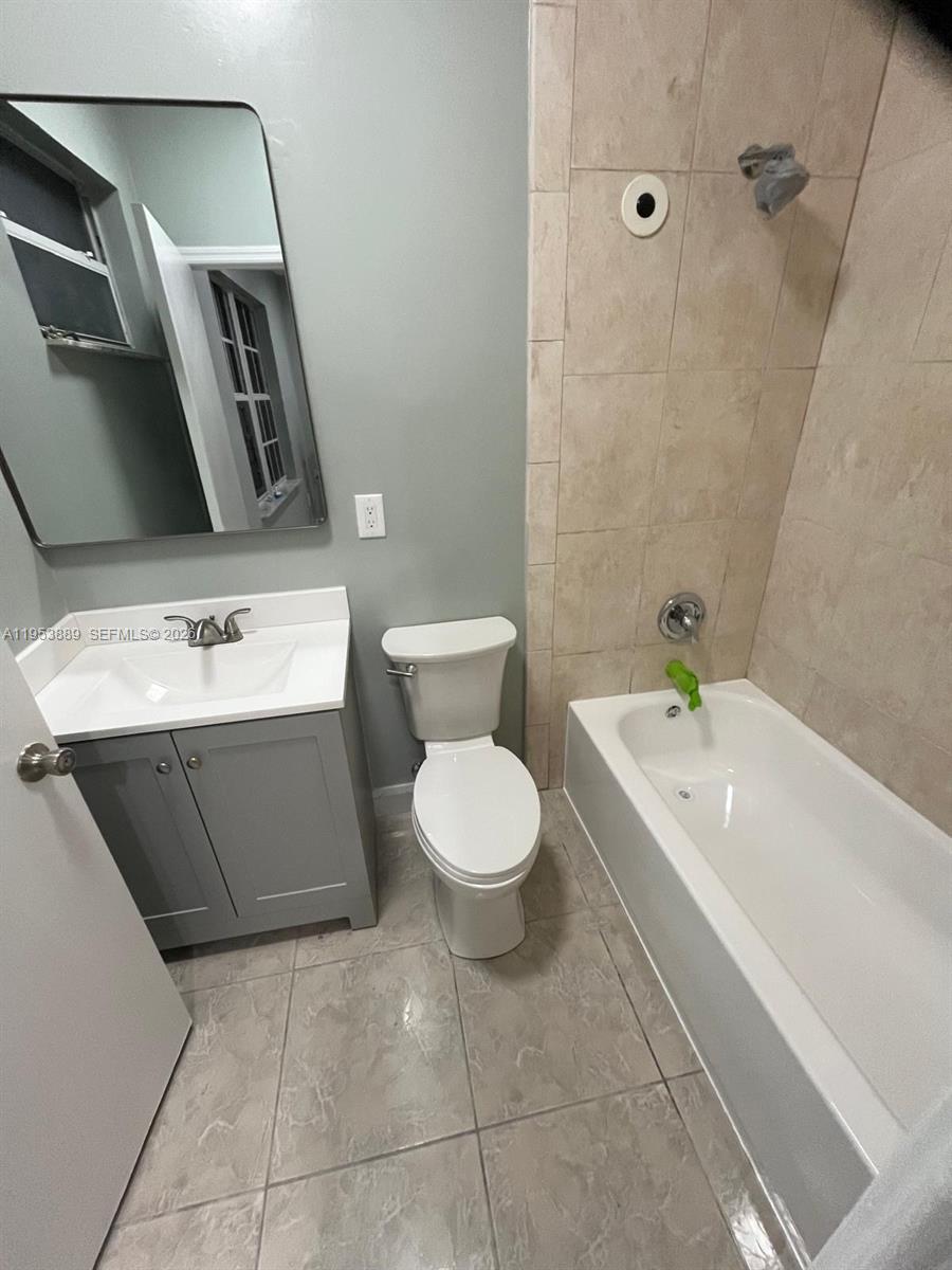 601 Northwest 97th Street, Unit 601 Miami, FL 33150 - Photo 11 of 16 a spacious bathroom with a toilet a sink and mirror