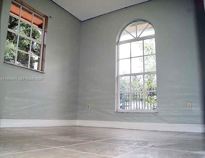 601 Northwest 97th Street, Unit 601 Miami, FL 33150 - Photo 11 of 14 an empty room with wooden floor and windows