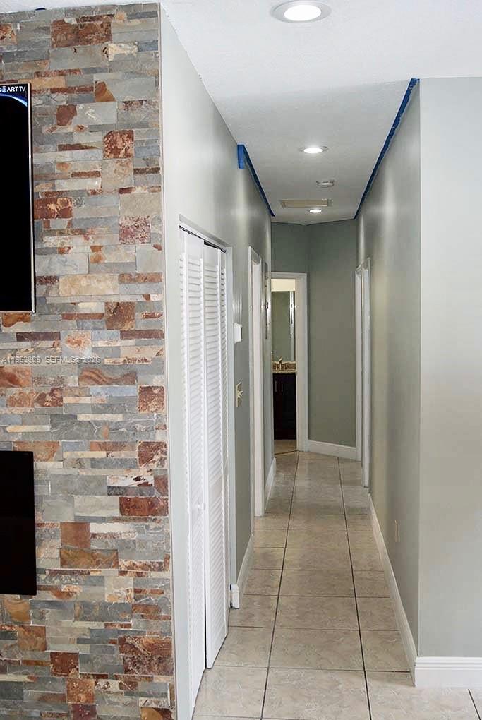 601 Northwest 97th Street, Unit 601 Miami, FL 33150 - Photo 6 of 16 a view of hallway with a brick wall and a fireplace