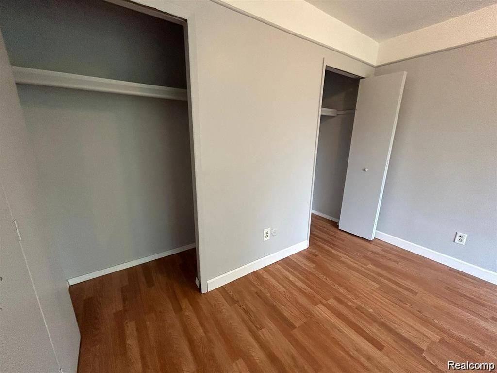 16480 East 9 Mile Road, Unit 102 Eastpointe, MI 48021 - Photo 12 of 13 Wood-finish flooring with light gray walls, featuring two built-in closet spaces