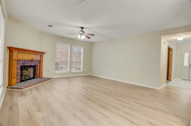 a view of a room with a ceiling fan hardwood floor and a ceiling fan
