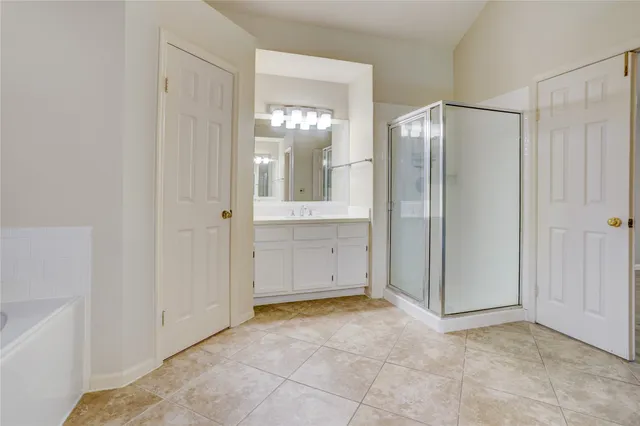 a view of a bathroom with mirror shower and a sink
