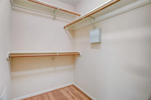 an empty room with wooden floor chandelier fan and windows