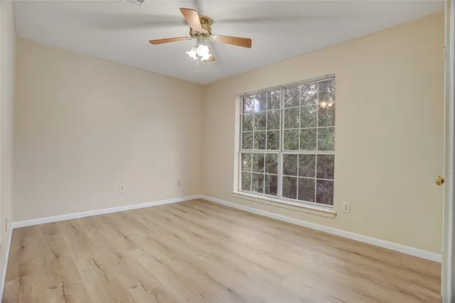 an empty room with wooden floor and cabinet