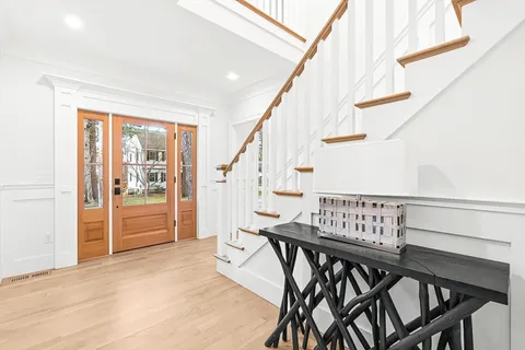 a view of entryway and hall with wooden floor