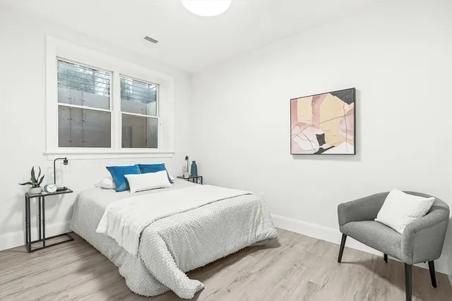 a bedroom with a bed and a large window