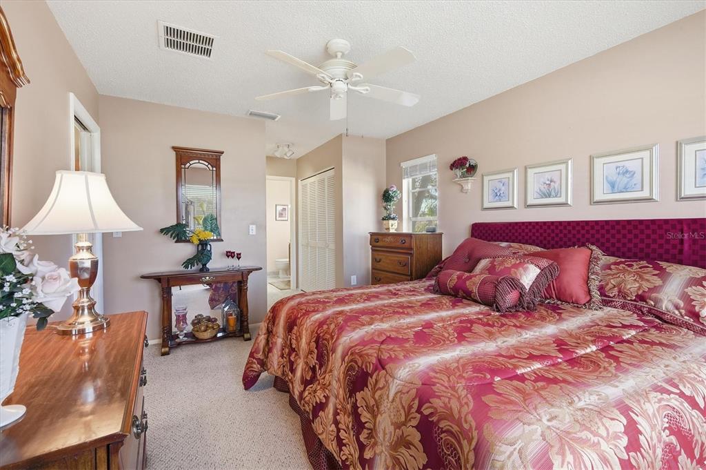 1802 69th Street West Bradenton, FL 34209 - Photo 18 of 31 a bedroom with a large bed and a chandelier