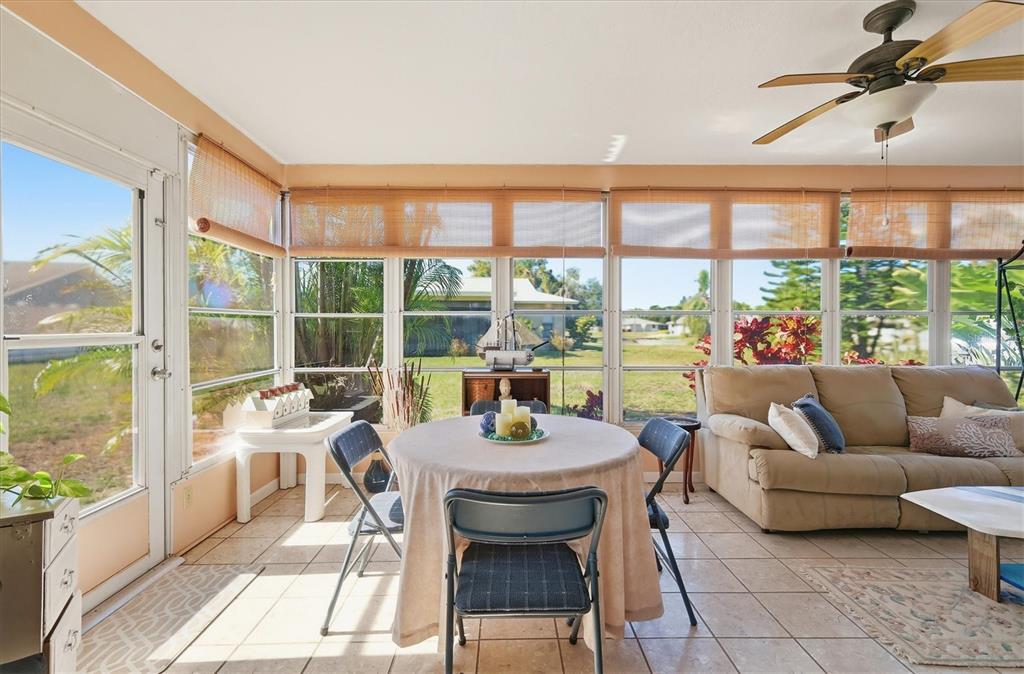 1802 69th Street West Bradenton, FL 34209 - Photo 26 of 31 a dining room with furniture a flat screen tv and a floor to ceiling window