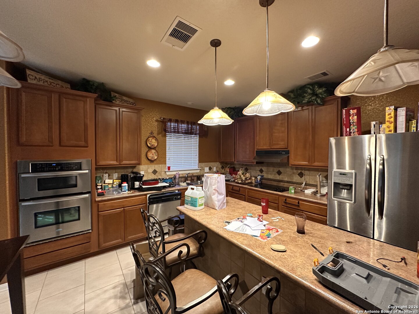 141 Springtree Gate Cibolo, TX 78108 - Photo 7 of 8 a kitchen with stainless steel appliances kitchen island granite countertop a sink stove and refrigerator