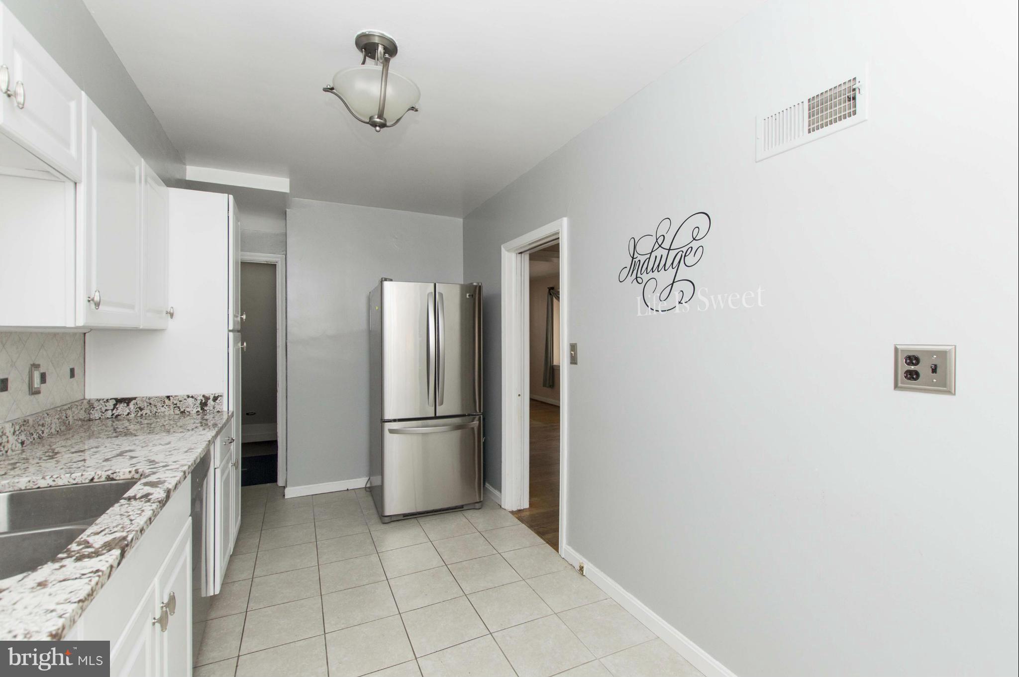 1254 Cedarcroft Road Baltimore, MD 21239 - Photo 11 of 30 a kitchen with a refrigerator and a sink