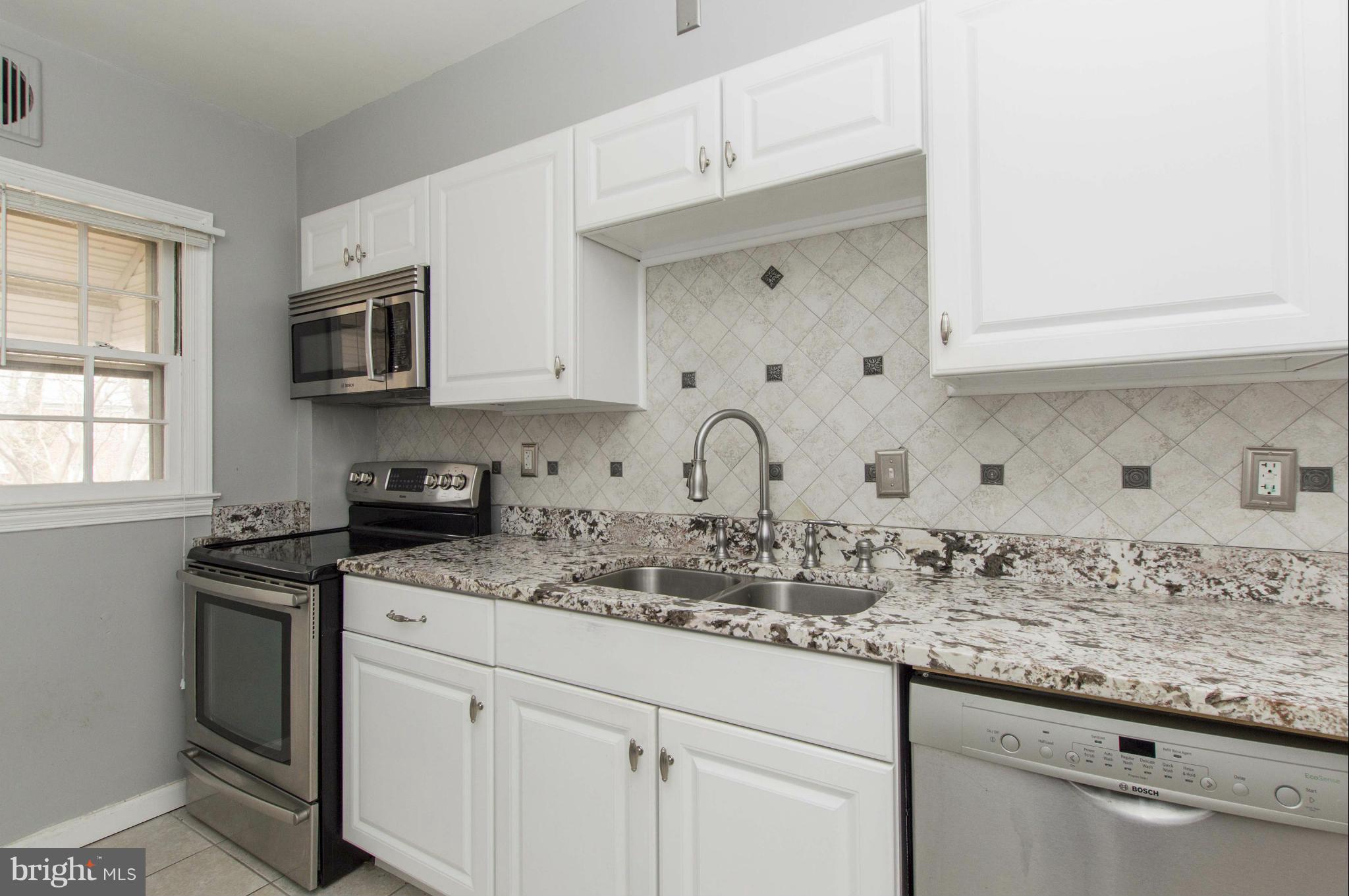 1254 Cedarcroft Road Baltimore, MD 21239 - Photo 13 of 30 a kitchen with granite countertop white cabinets and white appliances