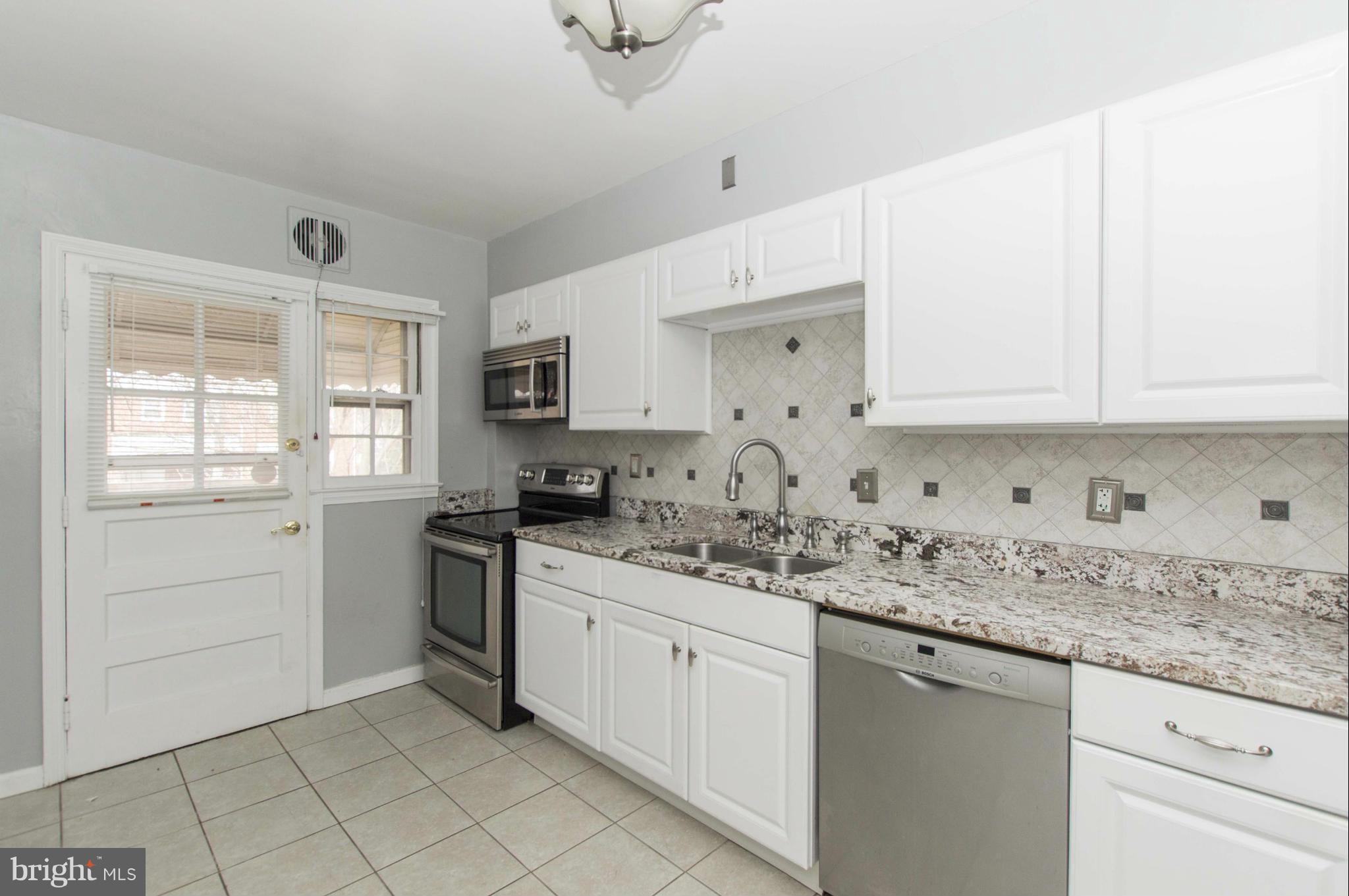 1254 Cedarcroft Road Baltimore, MD 21239 - Photo 14 of 30 a kitchen with granite countertop white cabinets stainless steel appliances a sink and a window