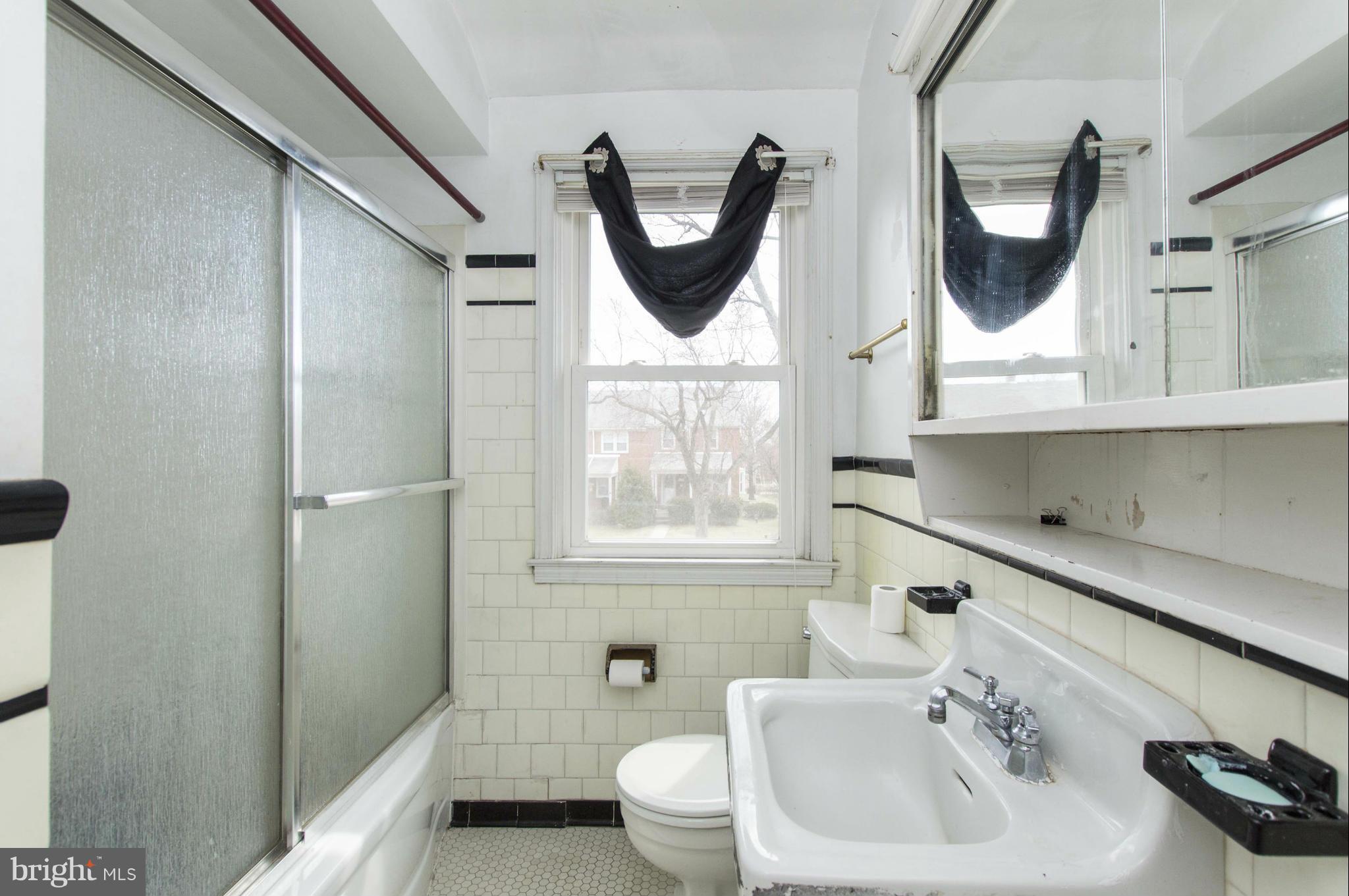 1254 Cedarcroft Road Baltimore, MD 21239 - Photo 17 of 30 a bathroom with a toilet a sink and mirror