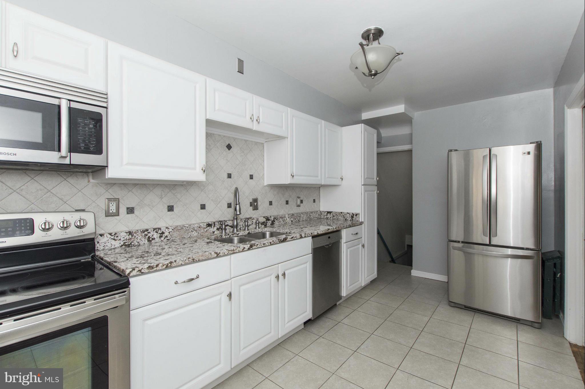 1254 Cedarcroft Road Baltimore, MD 21239 - Photo 9 of 30 a kitchen with a stove sink and refrigerator