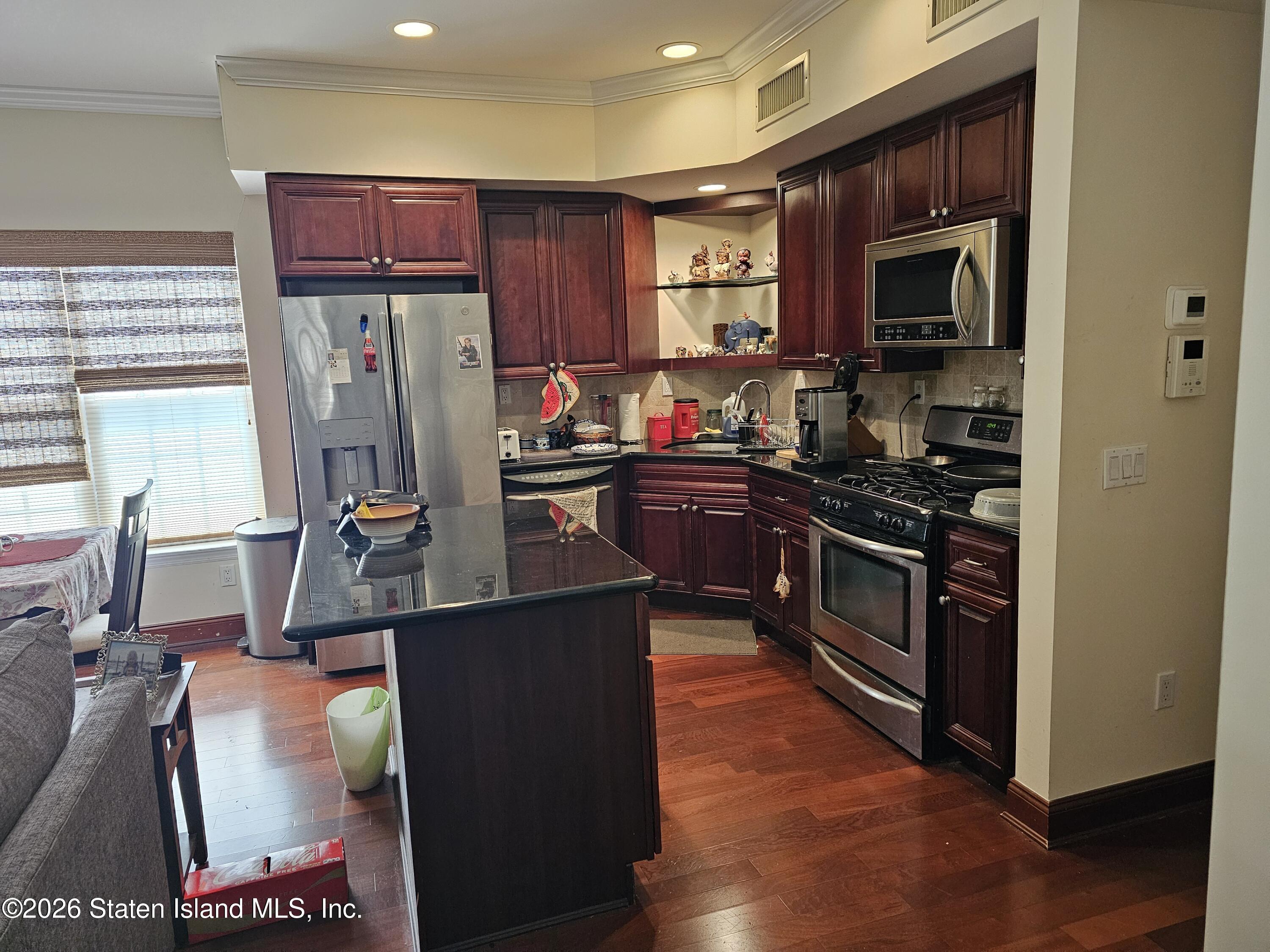 3871 Amboy Road, Unit 404 Staten Island, NY 10308 - Photo 4 of 17 a kitchen with stainless steel appliances a stove refrigerator sink and microwave