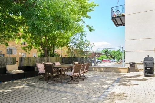 a view of a patio with a dining table and chairs with a small yard