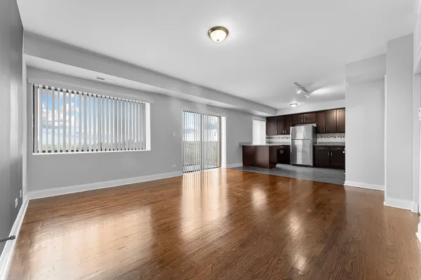 wooden floor in an empty room with a kitchen