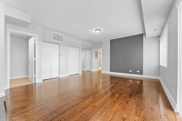 a view of an empty room with wooden floor