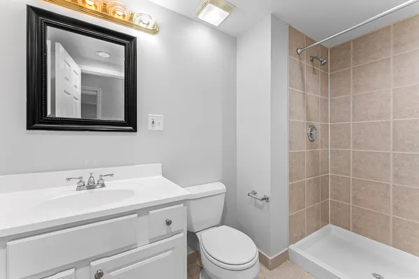 a bathroom with a toilet sink vanity and mirror