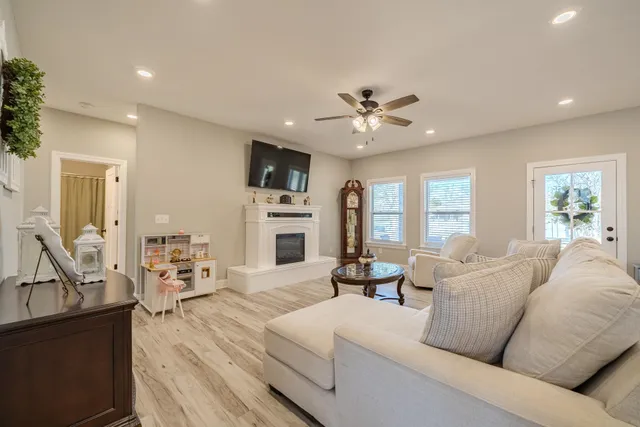 a living room with furniture a flat screen tv and a window