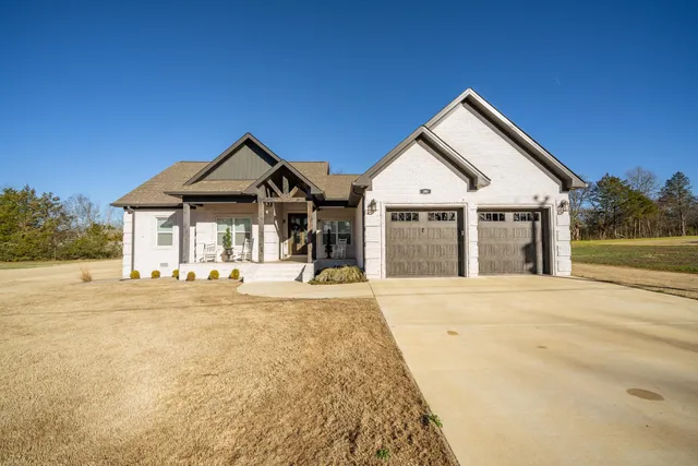 a front view of a house with a yard and seating space