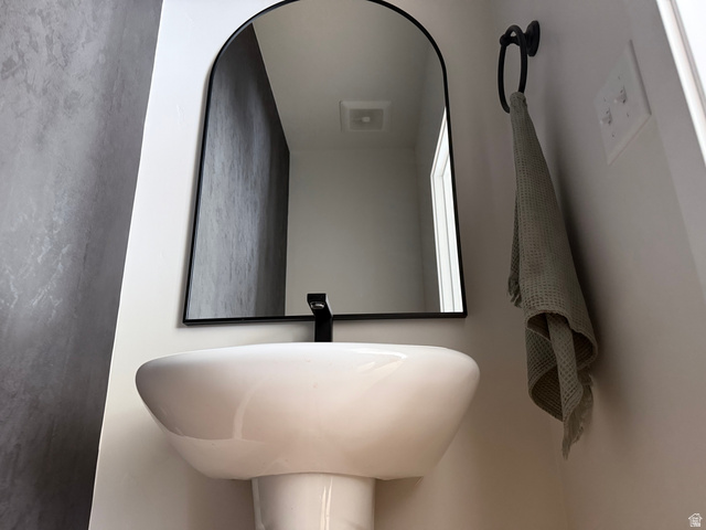 774 West 480 South American Fork, UT 84003 - Photo 30 of 76 Pedestal sink with a matte black wall-mounted faucet, complemented by an arched black-framed mirror