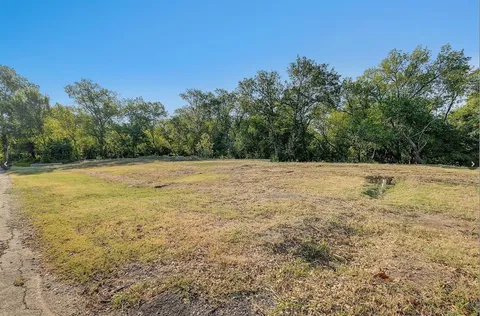 a view of a field with trees in the background