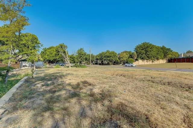a view of a field of grass and trees