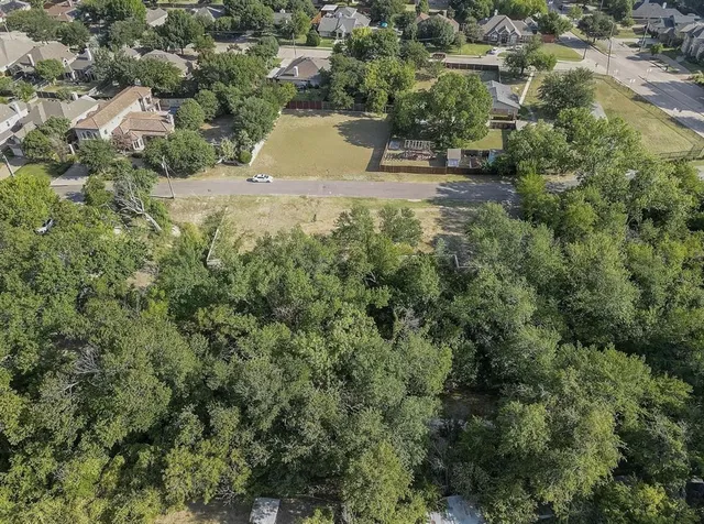 an aerial view of residential house with outdoor space and trees all around