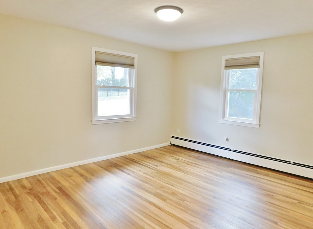 214 Hartwick Street Springfield, MA 01108 - Photo 14 of 25 an empty room with wooden floor and windows
