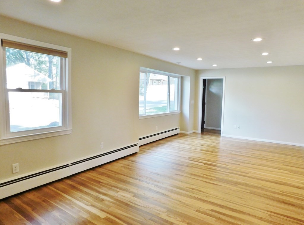 214 Hartwick Street Springfield, MA 01108 - Photo 8 of 25 a view of an empty room with wooden floor and a window