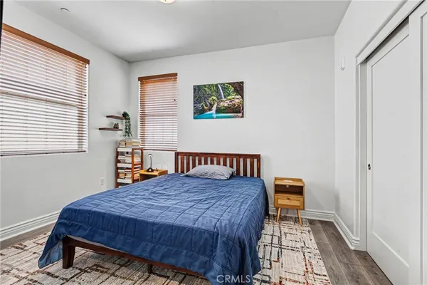 a bedroom with a bed and wooden floor