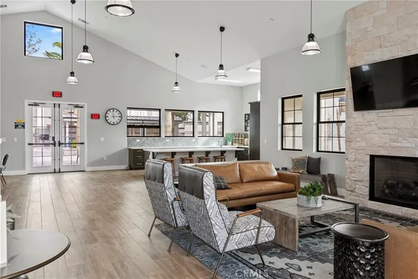 a living room with furniture floor to ceiling window and a flat screen tv