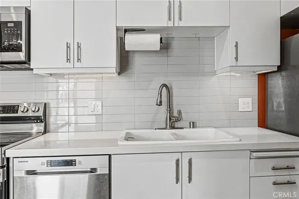 a kitchen with stainless steel appliances granite countertop a sink and a stove